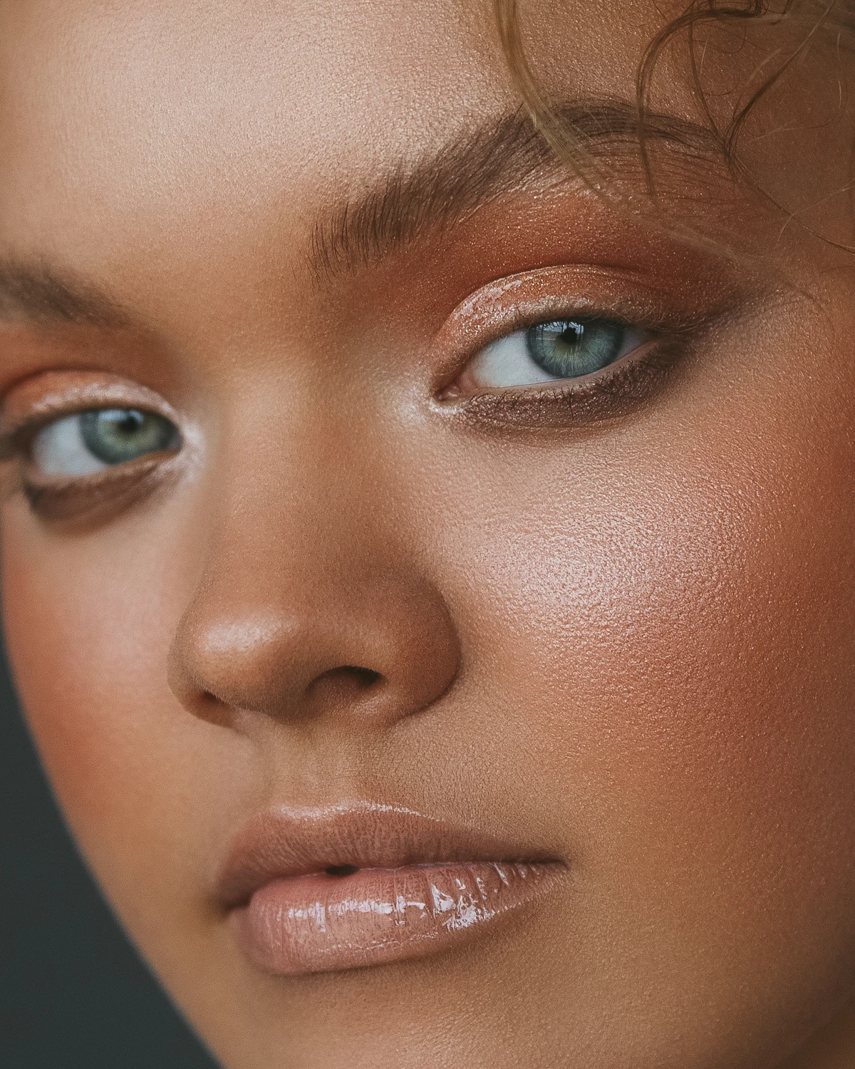 Lit-from-within bronze skin editorial close-up by Bonnie Gillies